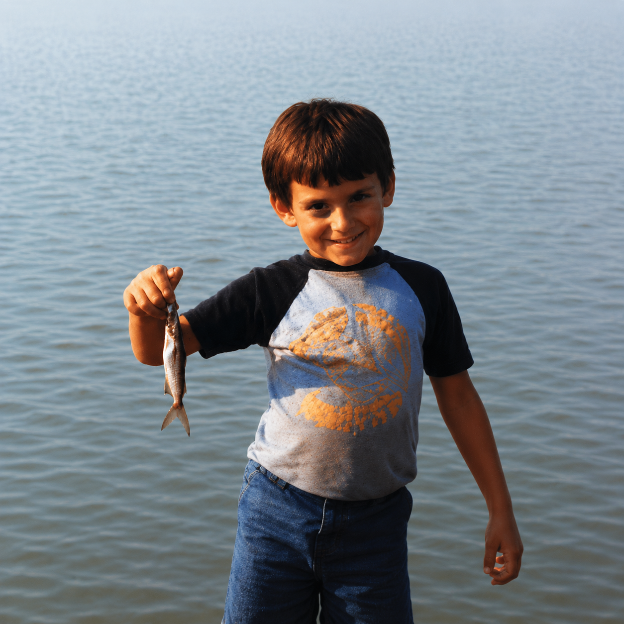 Young Brad as a kid by the water holding a fish — the blackout-period profile picture